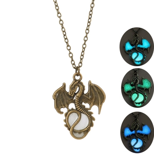 Detailed view of bronze dragon pendant showing three different glowing colors in the dark