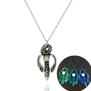 Detailed view of silver dragon pendant showing glowing beads in green and blue colors