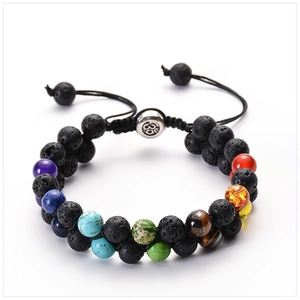 Macro detail of dual-layer lava rock and chakra stones bracelet with Om symbol bead