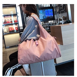Pink large capacity travel bag showing the trolley sleeve attached to a suitcase handle
