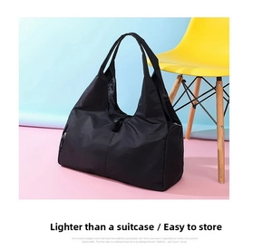 Close-up of black waterproof nylon travel bag with wide handles and side zipper detail