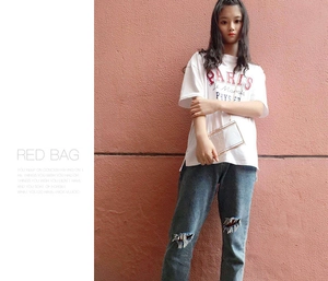 Detailed view of clear acrylic box clutch with metal chain strap and Paris graphic tee