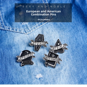 Detail of punk Halloween enamel pin set featuring coffin and magic spellbook designs.