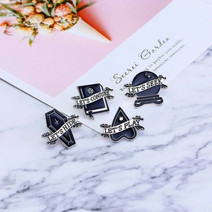 Detailed view of occult enamel pins featuring coffin, spell book, and crystal ball