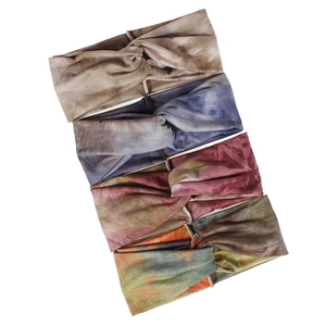 Detail of four tie-dye bohemian elastic headbands in taupe blue red and multi-color