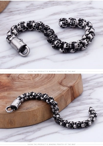 Detailed view of vintage silver skull links on a punk style stainless steel bracelet