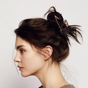 Detail view of large rose gold hollow mesh geometric hair claw clip on model's hair