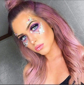 Detailed view of colorful acrylic resin face jewels and rhinestones on eye area