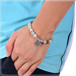 Detailed close-up of 8mm Amazonite beads bracelet with a silver lotus charm on wrist