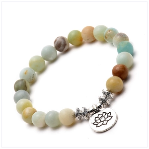 Macro shot of Amazonite matte stone beads with a silver lotus charm and vintage spacers