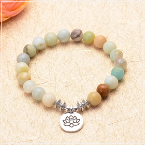 Macro shot of 8mm amazonite yoga beads featuring a detailed silver lotus charm pendant
