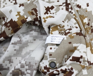 Macro view of ripstop polyester fabric with metal ventilation eyelets on the camo boonie hat
