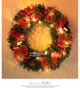 Détail d'une couronne de Noël avec nœud rouge, petits cadeaux et lumières LED chaudes