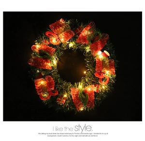 Gros plan d'une couronne de Noël lumineuse avec LED chaudes et ornements de cadeaux