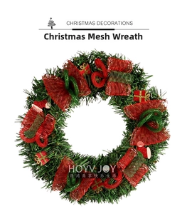 Détail d'une couronne de Noël avec nœuds en résille rouge et petits cadeaux décoratifs