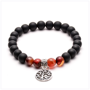 Macro view of beaded bracelet with black lava stone, tiger eye, and tree of life charm