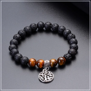Detailed view of volcanic lava stone and tiger eye beads with silver tree of life charm