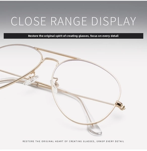 Macro detail of gold metal pilot glasses frames showing the double bridge and nose pads
