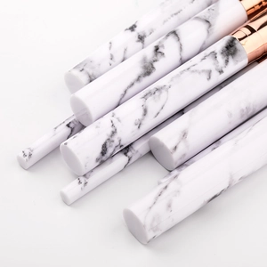 Detailed shot of makeup brushes with white marble handles and rose gold ferrules