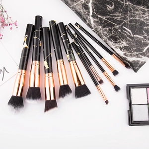 Flat lay of 10 marble handle makeup brushes with rose gold ferrules and gradient bristles