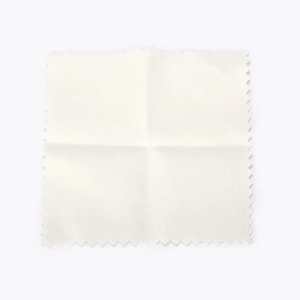 Close-up of square off-white microfiber jewelry cleaning cloth with serrated edges