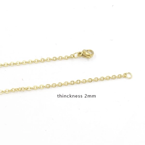Detail view of 2mm golden stainless steel cable chain with lobster clasp and round ring