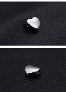 Macro shot of silver stainless steel heart beads with horizontal holes for DIY jewelry