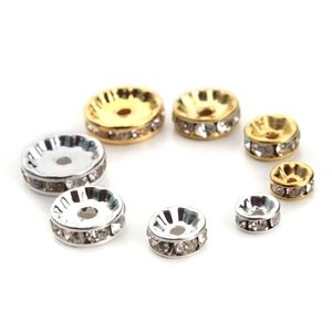 Close-up of sparkling gold and silver rhinestone spacer beads in various sizes for DIY jewelry