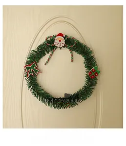 Detail showing a green PVC Christmas wreath with Santa charm and red striped bow tie