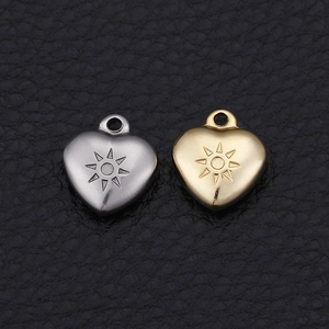 Golden and silver heart pendants with sun pattern on black leather background