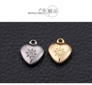 Detail showing heart-shaped titanium steel pendants with sun engraving in gold and silver