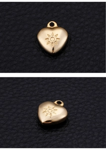 Macro detail of golden heart pendant with sunburst engraving on black leather