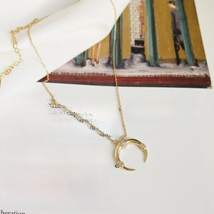 925 silver crescent moon necklace with sparkling crystals on decorative art book