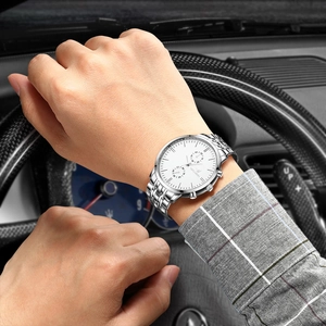 Close-up of Orlando silver mesh band watch worn on wrist in a luxury car interior