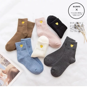 Detail view of cotton crew socks featuring delicate gold heart embroidery in six colors