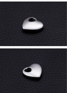 Macro shot of silver polished heart-shaped stainless steel pendant on black leather