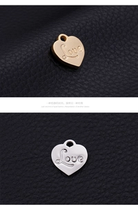 Macro detail of gold and silver heart pendants with Love engraving on leather surface