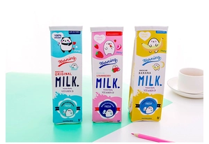Three creative milk carton pencil cases in blue, pink, and yellow colors on a desk
