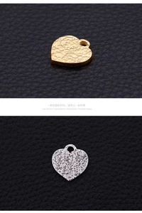 Detailed view of heart-shaped pendants with hammered texture in gold and silver finish