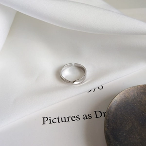 Macro shot of silver mobius twist ring on white silk with minimalist elegant design