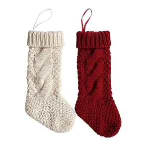Detailed macro of cream and red cable-knit Christmas stockings with hanging loops