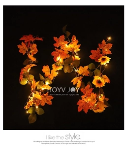 Detail of autumn garland with sunflowers, maple leaves, and warm LED fairy lights