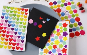 Close-up of colorful heart, star, and circle stickers for DIY scrapbooks and planners