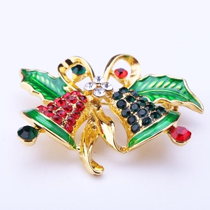 Detail of Christmas bell brooch with red and green rhinestones on gold ribbon