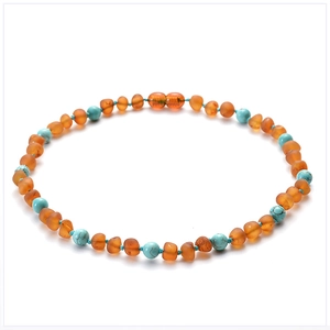 Detailed shot of amber and turquoise beads on a handmade baby teething necklace