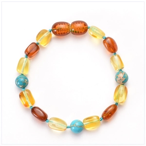 Detailed macro view of handmade Baltic amber baby bracelet with turquoise stones