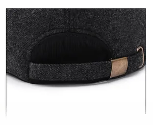 Close-up of adjustable strap with brass buckle on dark grey wool winter baseball cap