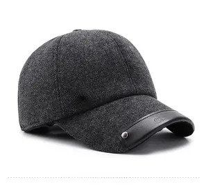 Detailed view of dark gray wool baseball cap with metal logo and leather brim accent