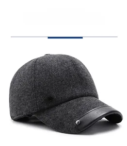 Detail of dark gray wool baseball cap with metal logo and black leather brim accent