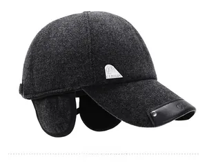 Detail view of winter baseball cap with ear flaps and silver decorative logo tag
